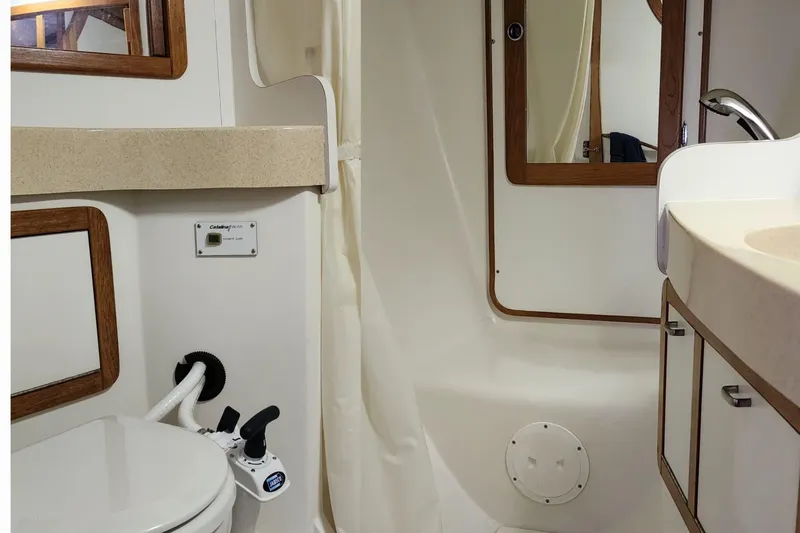 Slide: The Image of 1998 Catalina 42 MkII sailboat with American flag, docked on a sunny day. - 4