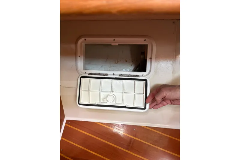 Slide: The Image of Hand opening compartment on 1998 Catalina 42 MkII sailboat with wooden flooring. - 40