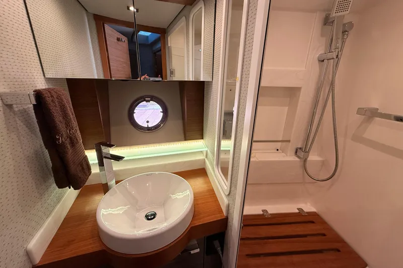 Slide: The Image of Luxurious bathroom in 2020 Tiara Yachts C44 Coupe with modern fixtures and porthole window. - 19