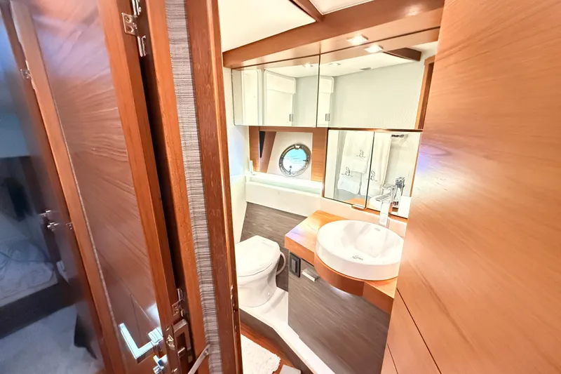 Slide: The Image of Luxurious cabin interior of 2020 Tiara Yachts C44 Coupe with elegant bedding and porthole windows. - 28