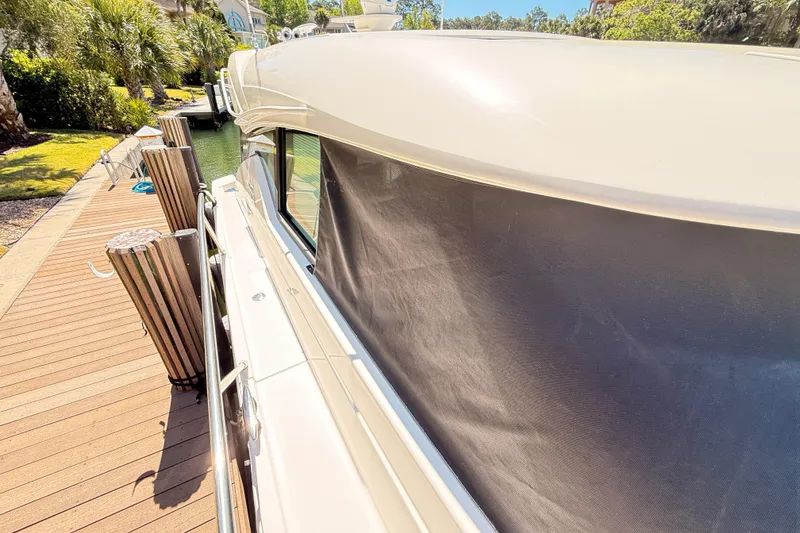 Slide: The Image of 2020 Tiara Yachts C44 Coupe docked by a scenic waterfront. - 42