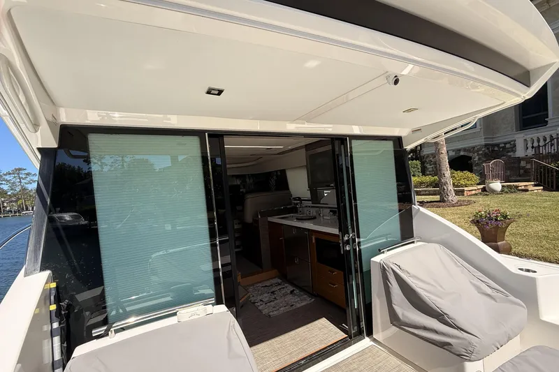 Slide: The Image of 2020 Tiara Yachts C44 Coupe deck with covered seating, dockside view. - 5