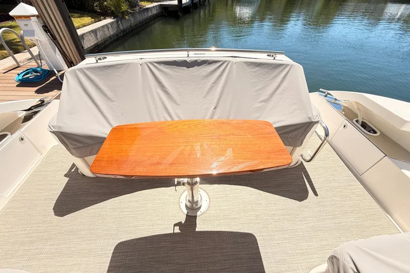 Slide: The Image of 2020 Tiara Yachts C44 Coupe docked by serene waterfront, showcasing luxury design. - 51