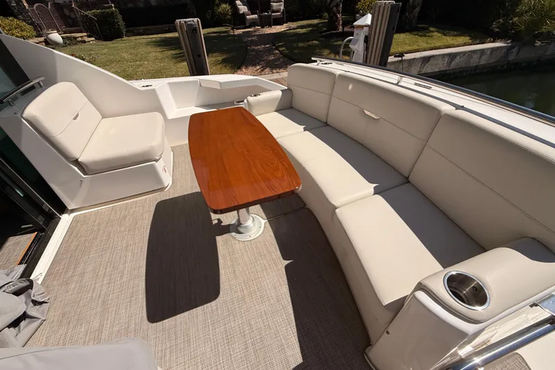 Slide: The Image of 2020 Tiara Yachts C44 Coupe with elegant seating and wooden table on deck. - 55