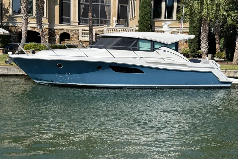 Slide: The Image of 2020 Tiara Yachts C44 Coupe in water, elegant design, near luxury waterfront property. - 61
