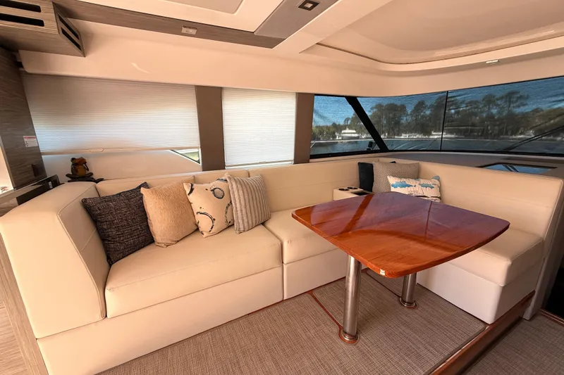 Slide: The Image of 2020 Tiara Yachts C44 Coupe with open sliding doors, revealing interior and outdoor seating. - 7