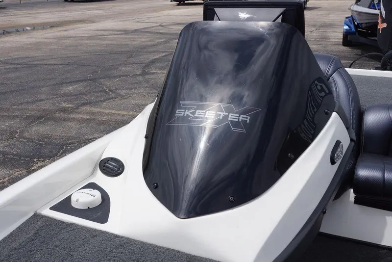 Slide: The Image of 2013 Skeeter ZX190 boat console with windshield and logo, parked on pavement. - 21