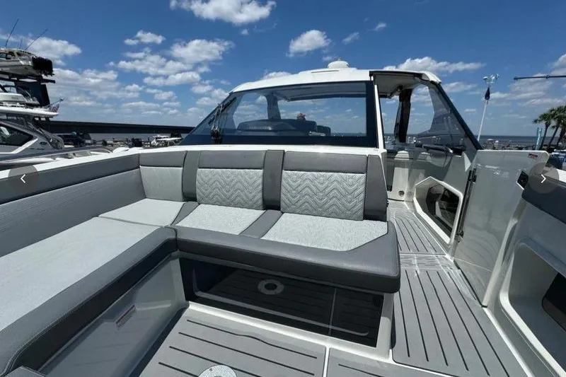 Slide: The Image of 2022 Galeon 325 GTO boat interior with gray seating and open deck under blue sky. - 5