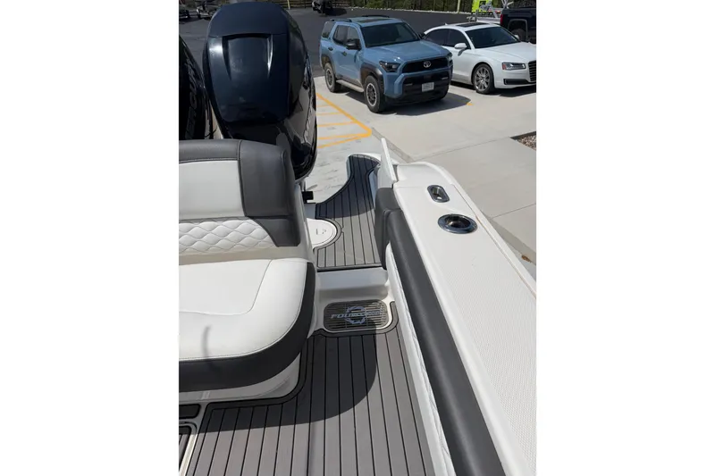 Slide: The Image of 2018 Fountain 39 NX boat interior with seating and motor, parked near vehicles. - 14