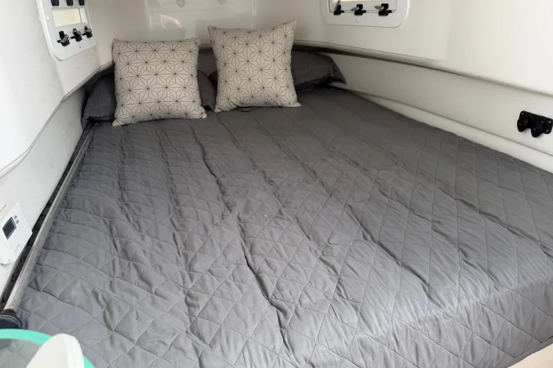 Slide: The Image of Cozy cabin bed in 2018 Fountain 39 NX boat with gray quilt and patterned pillows. - 33