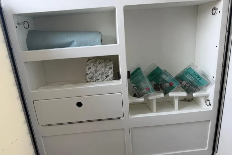 Slide: The Image of Storage compartment in a 2018 Fountain 39 NX boat with paper towels and packaged items. - 38