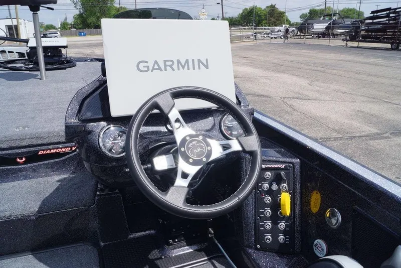 Slide: The Image of 2026 Phoenix 921 Elite X boat dashboard with Garmin navigation system and steering wheel. - 13