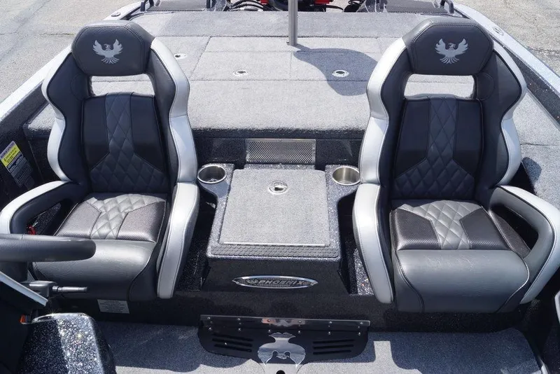 Slide: The Image of 2026 Phoenix 921 Elite X boat interior with dual black and gray seats, cup holders, and storage. - 16