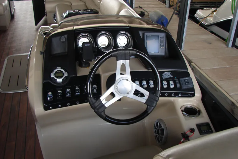 Slide: The Image of 2015 Bennington 2875 QCW I/O boat dashboard with steering wheel and control panel. - 18