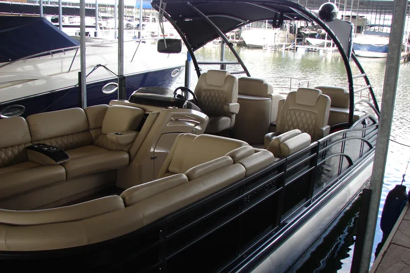 Slide: The Image of 2015 Bennington 2875 QCW I/O pontoon boat with luxurious seating in marina. - 2