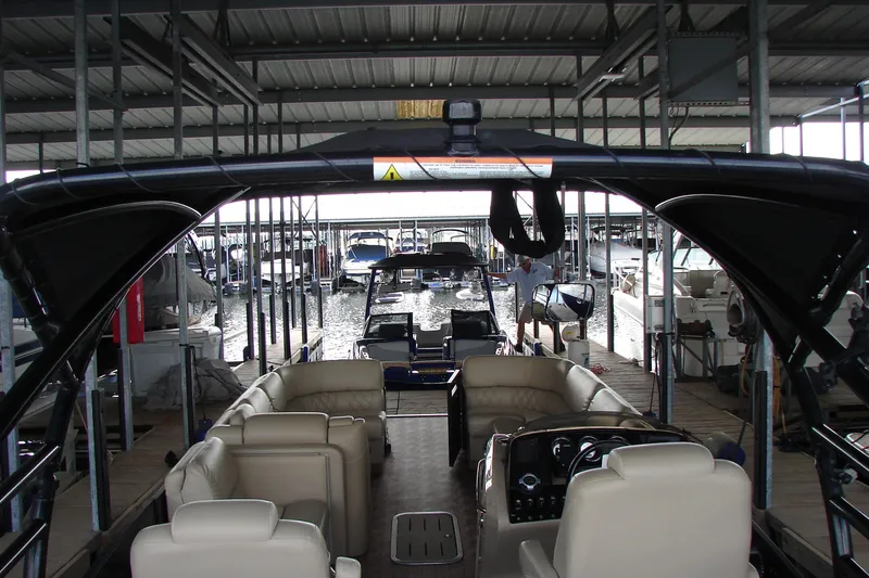 Slide: The Image of 2015 Bennington 2875 QCW I/O pontoon boat docked in a marina. - 23