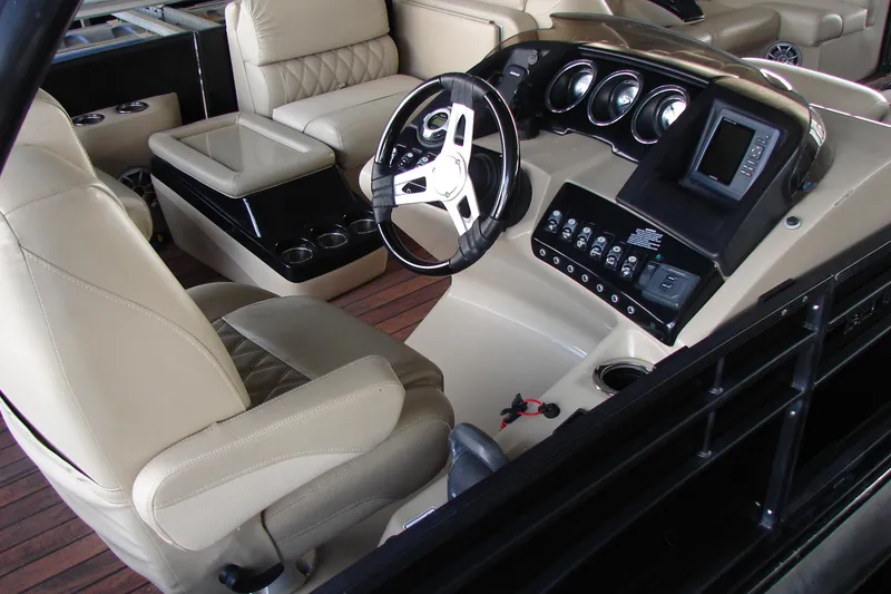 Slide: The Image of Interior of 2015 Bennington 2875 QCW I/O boat with beige seating and modern dashboard. - 8