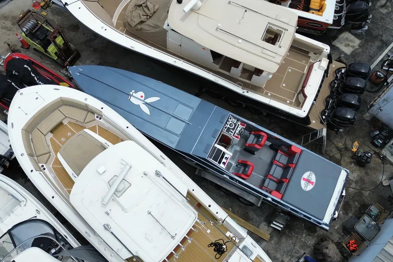 Slide: The Image of Aerial view of a 1994 Cigarette 38' Top Gun GT boat docked among other vessels. - 11