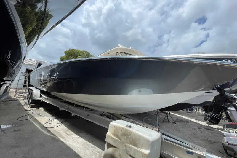 Slide: The Image of 1994 Cigarette 38' Top Gun GT boat on trailer under cloudy sky. - 13