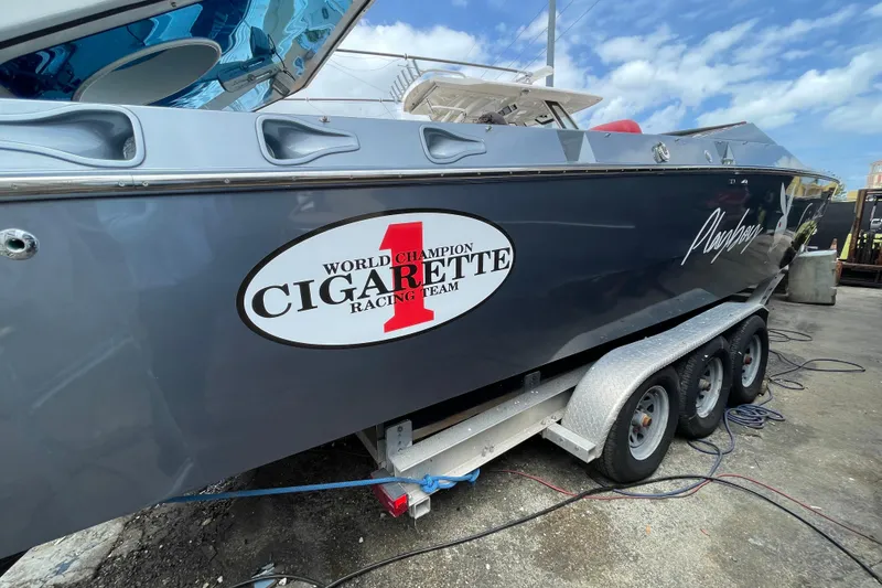 Slide: The Image of 1994 Cigarette 38' Top Gun GT boat on trailer, featuring racing team logo. - 14
