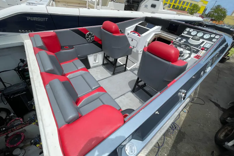 Slide: The Image of 1994 Cigarette 38' Top Gun GT boat interior with red and gray seating and control panel. - 17