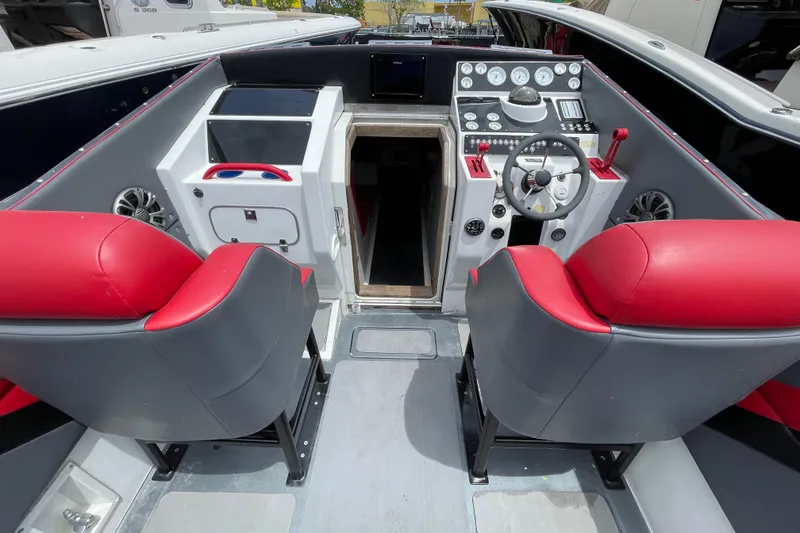 Slide: The Image of 1994 Cigarette 38' Top Gun GT boat cockpit with red and gray seating, steering wheel, and controls. - 19