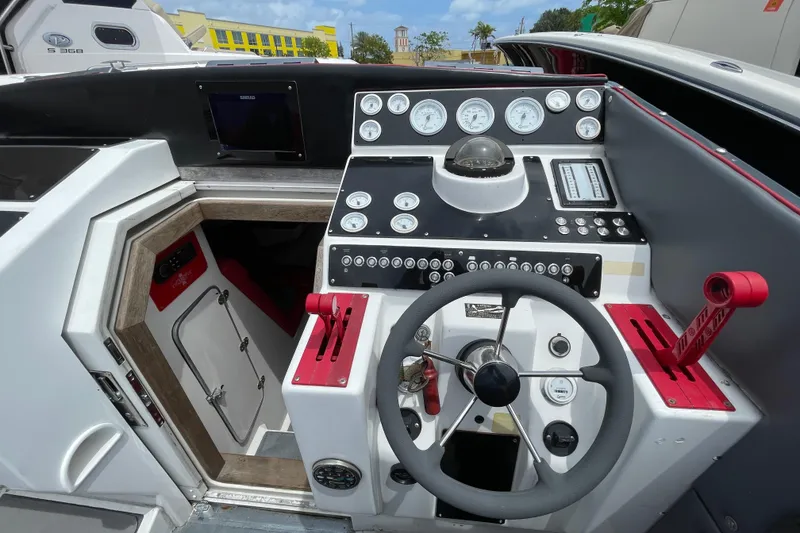 Slide: The Image of Cockpit of a 1994 Cigarette 38' Top Gun GT boat with steering wheel and control panel. - 22