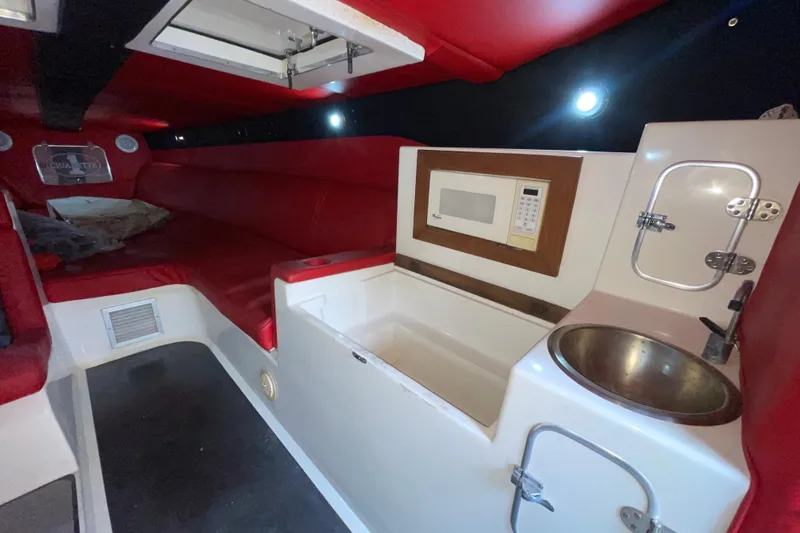 Slide: The Image of Interior of a 1994 Cigarette 38' Top Gun GT boat with red seating and kitchenette. - 29