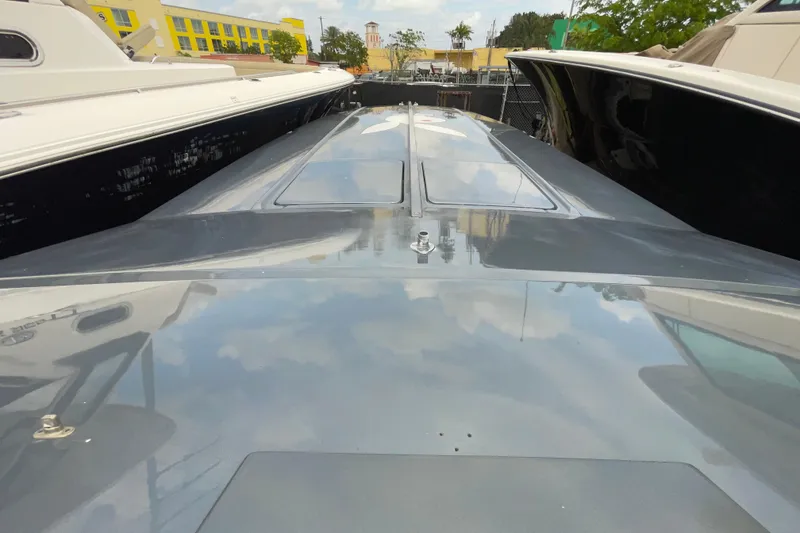 Slide: The Image of 1994 Cigarette 38' Top Gun GT boat, sleek design, docked between other boats. - 37