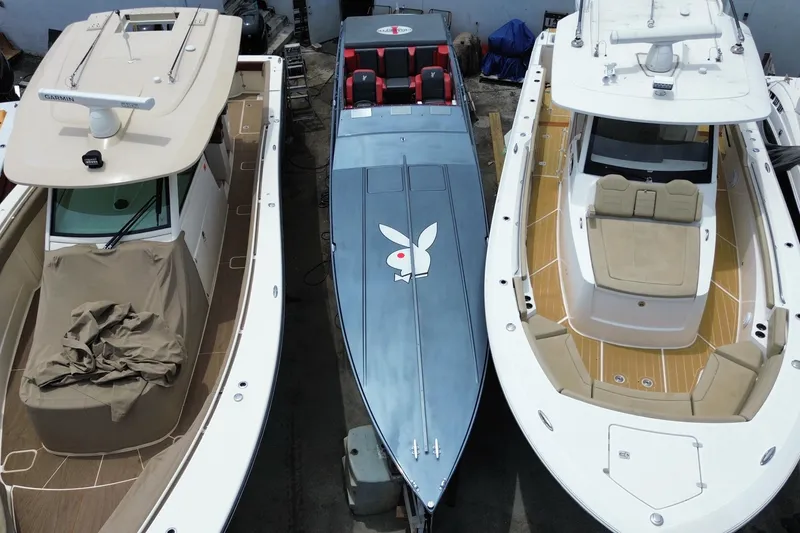 Slide: The Image of 1994 Cigarette 38' Top Gun GT boat with distinctive logo, docked between two other boats. - 4