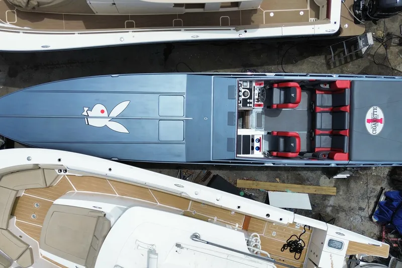 Slide: The Image of Aerial view of a 1994 Cigarette 38' Top Gun GT speedboat with red seating and sleek design. - 46