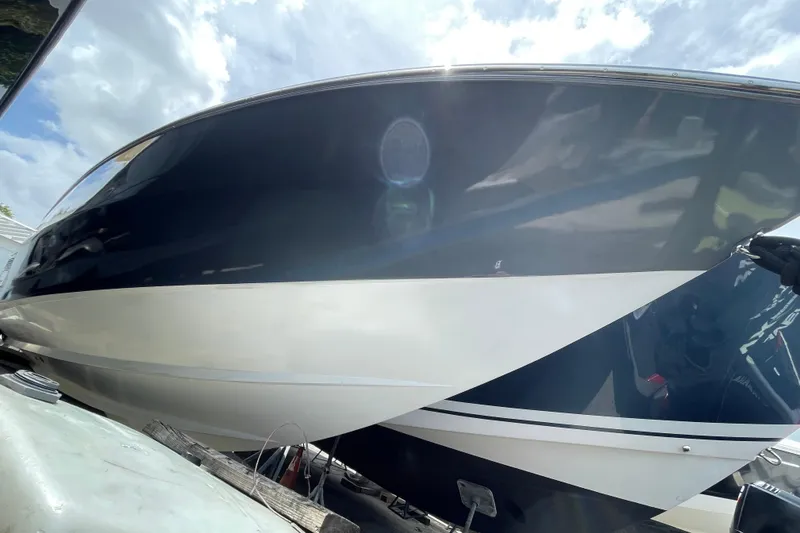 Slide: The Image of 1994 Cigarette 38' Top Gun GT boat with sleek black and white hull design. - 5