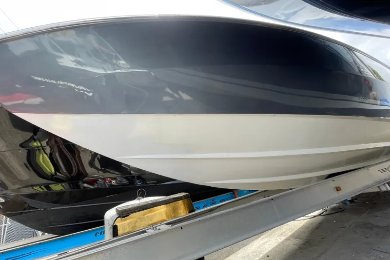 Slide: The Image of 1994 Cigarette 38' Top Gun GT boat on trailer, sleek black and white hull design. - 6