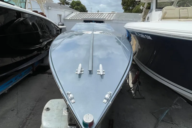 Slide: The Image of 1994 Cigarette 38' Top Gun GT boat, sleek design, docked between two other boats. - 7