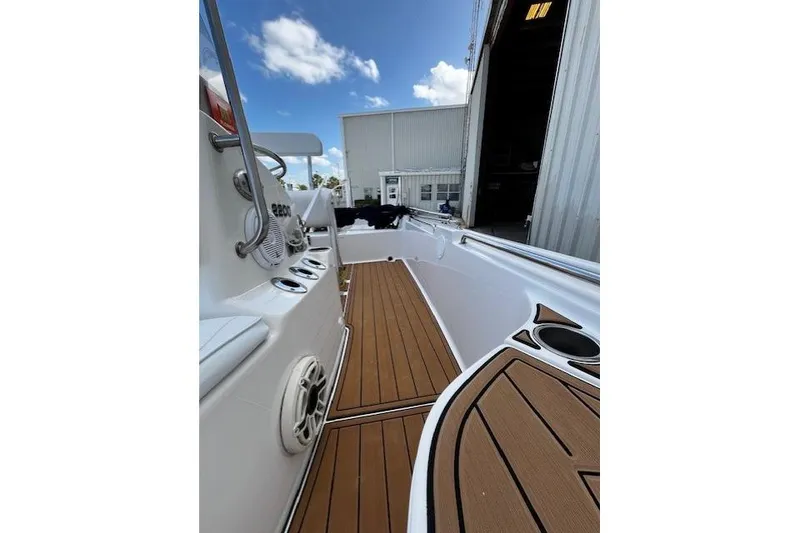Slide: The Image of 2017 Bulls Bay 2200 boat interior with teak flooring and white console under blue sky. - 10