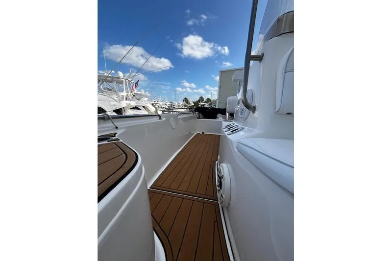 Slide: The Image of 2017 Bulls Bay 2200 boat deck with wooden flooring and clear blue sky. - 11