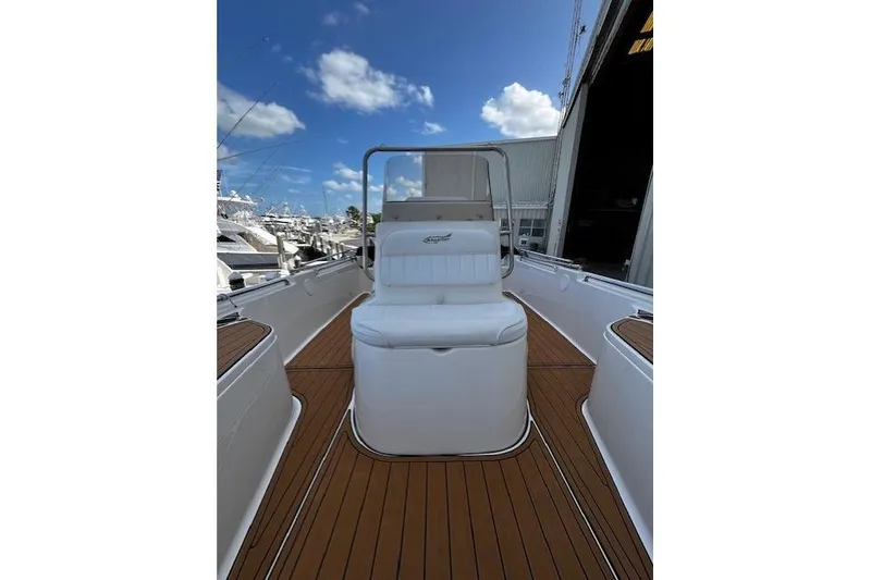 Slide: The Image of 2017 Bulls Bay 2200 boat with white seating and wooden deck, docked under a clear blue sky. - 8