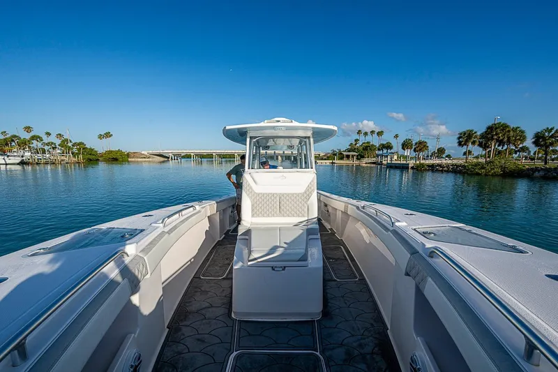 Slide: The Image of 2021 Streamline 35 CC boat on calm water, clear sky, palm trees in background. - 27