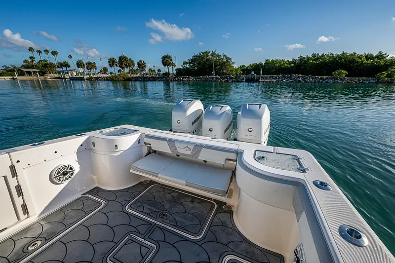 Slide: The Image of 2021 Streamline 35 CC boat with triple engines on calm water, scenic backdrop. - 30