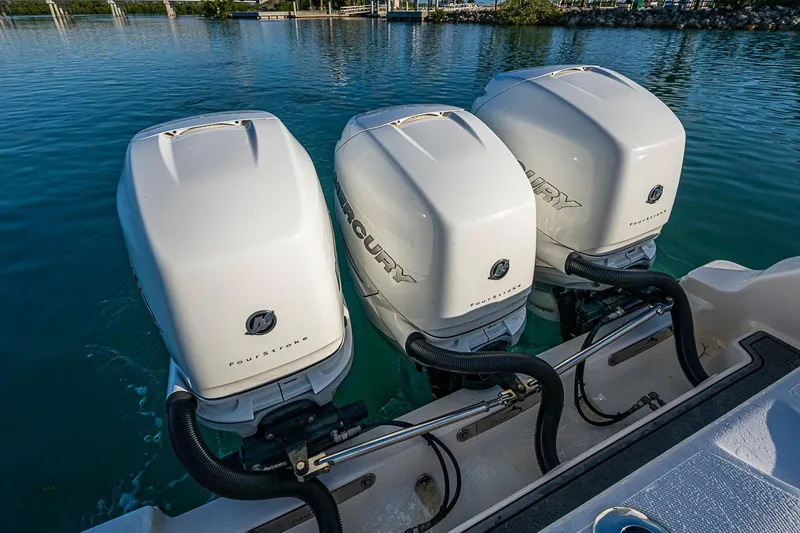 Slide: The Image of Triple Mercury outboard engines on a 2021 Streamline 35 CC boat in calm waters. - 36