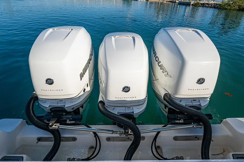 Slide: The Image of Triple Mercury outboard engines on a 2021 Streamline 35 CC boat in clear water. - 37
