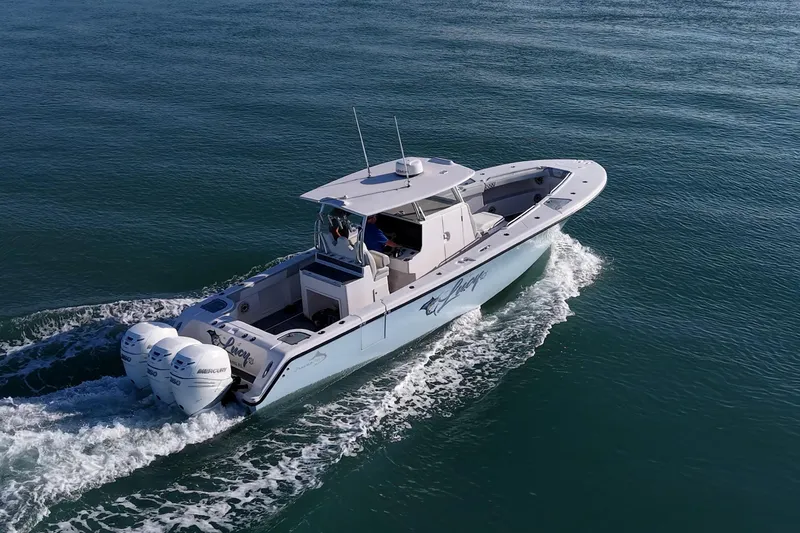 Slide: The Image of 2021 Streamline 35 CC boat cruising on open water with triple outboard engines. - 54