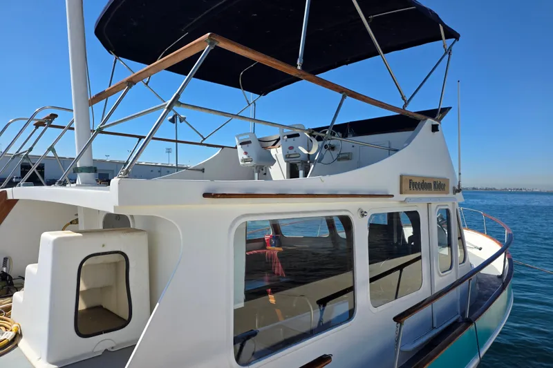 Slide: The Image of 1970 Defver 40 boat named "Freedom Rider" docked on a sunny day. - 2