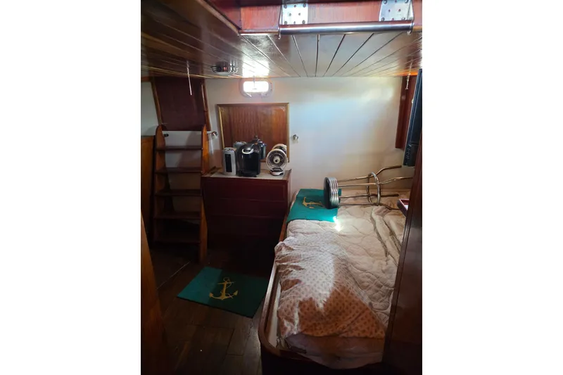 Slide: The Image of 1970 Defver 40 boat cabin interior with wooden finish and cozy bedding. - 6