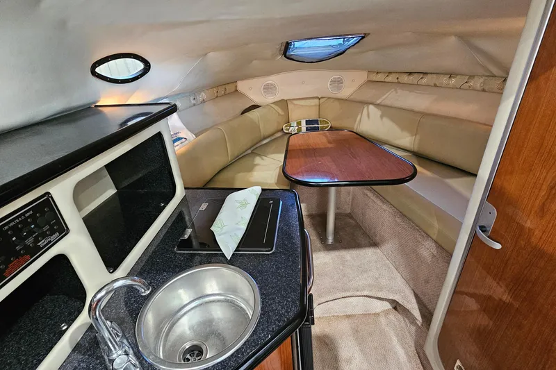 Slide: The Image of 2001 Chaparral Signature 240 cabin interior with kitchenette, sink, and cozy seating area. - 12