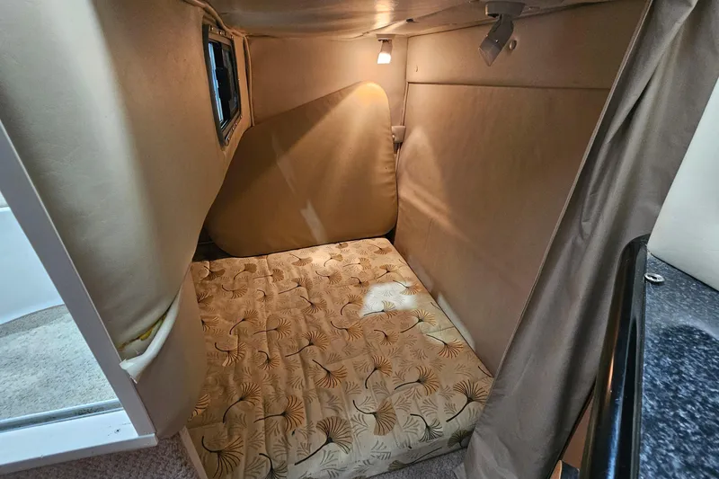 Slide: The Image of 2001 Chaparral Signature 240 cabin interior with patterned mattress and soft lighting. - 15