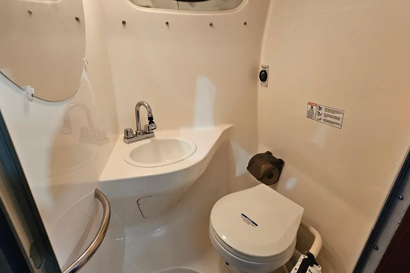 Slide: The Image of 2001 Chaparral Signature 240 boat bathroom with sink, toilet, and mirror. - 17