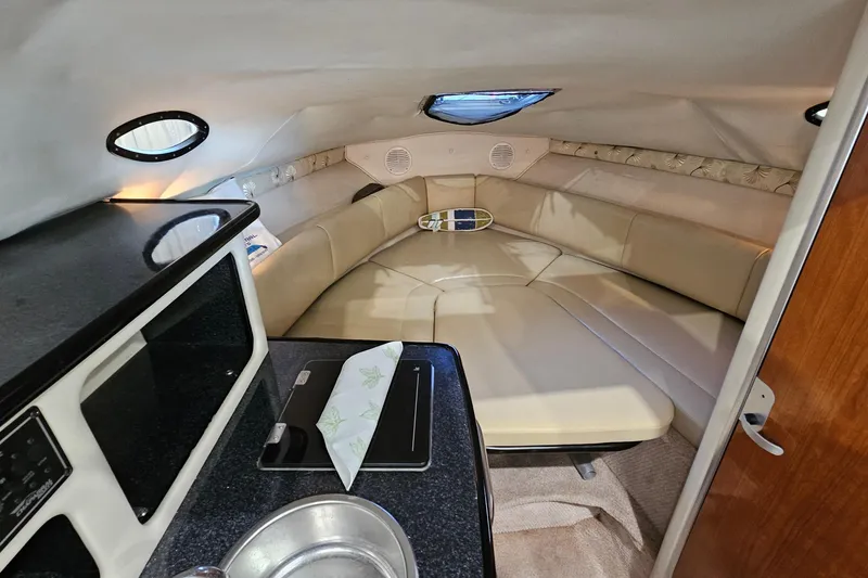 Slide: The Image of Interior of 2001 Chaparral Signature 240 boat, featuring cozy seating and compact kitchenette. - 18