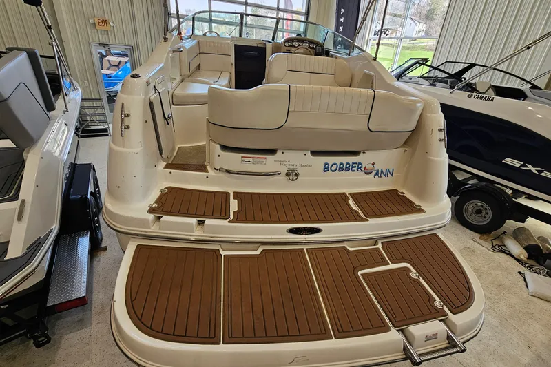 Slide: The Image of 2001 Chaparral Signature 240 boat with teak deck, beige seating, and interior view in showroom. - 4