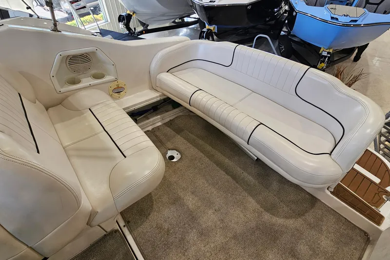 Slide: The Image of Interior seating of a 2001 Chaparral Signature 240 boat, featuring white upholstery and cup holders. - 7